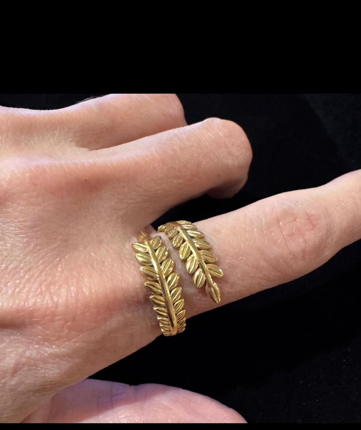 Gold leaf ring on a finger against a black background  - Ali & Eve Jewels