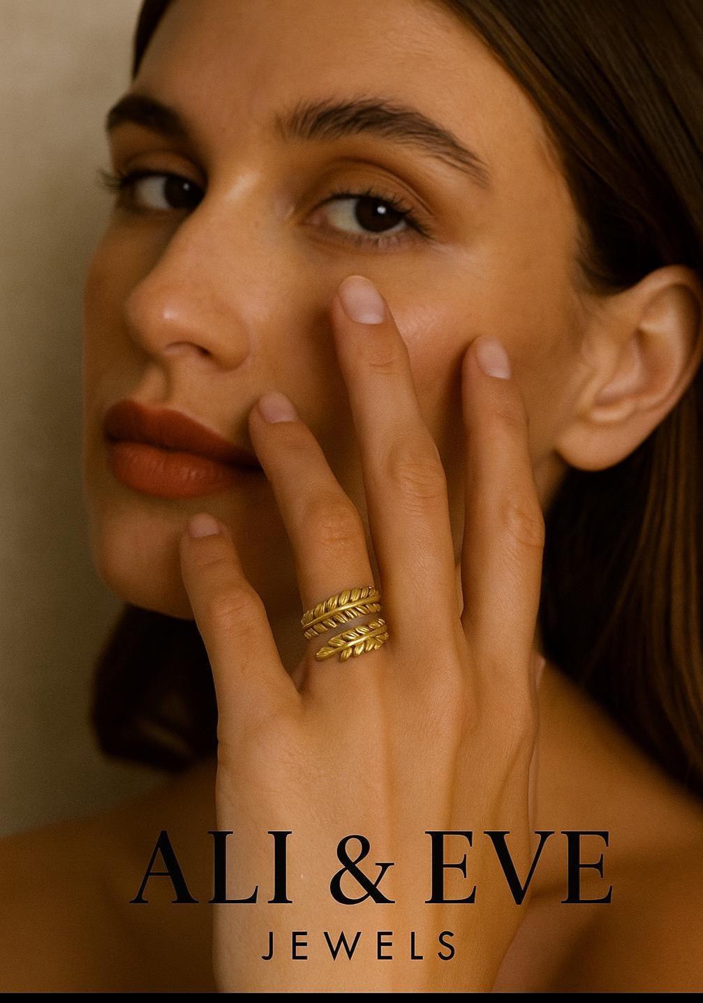 Woman wearing gold leaf ring with 'ALI & EVE JEWELS' branding