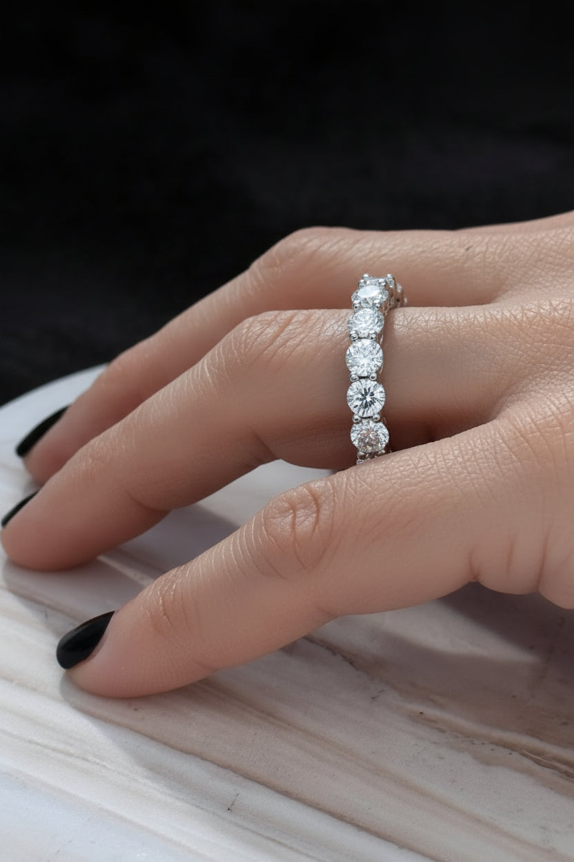 Diamond ring on a finger with a light blue background - Ali & Eve Jewels