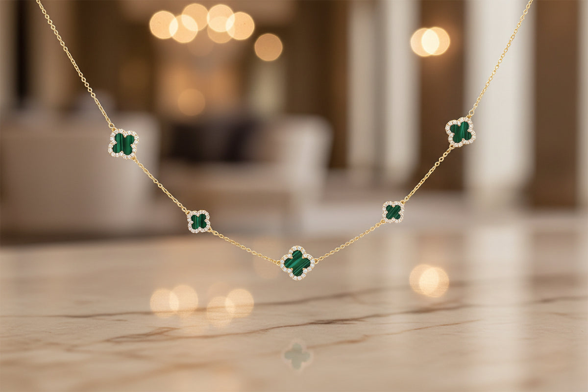 Gold necklace with green gemstone pendants on a person's neck