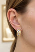 Gold earring with a diamond on an ear