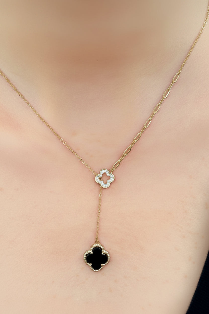 Gold necklace with clover-shaped black onyx pendant on a model