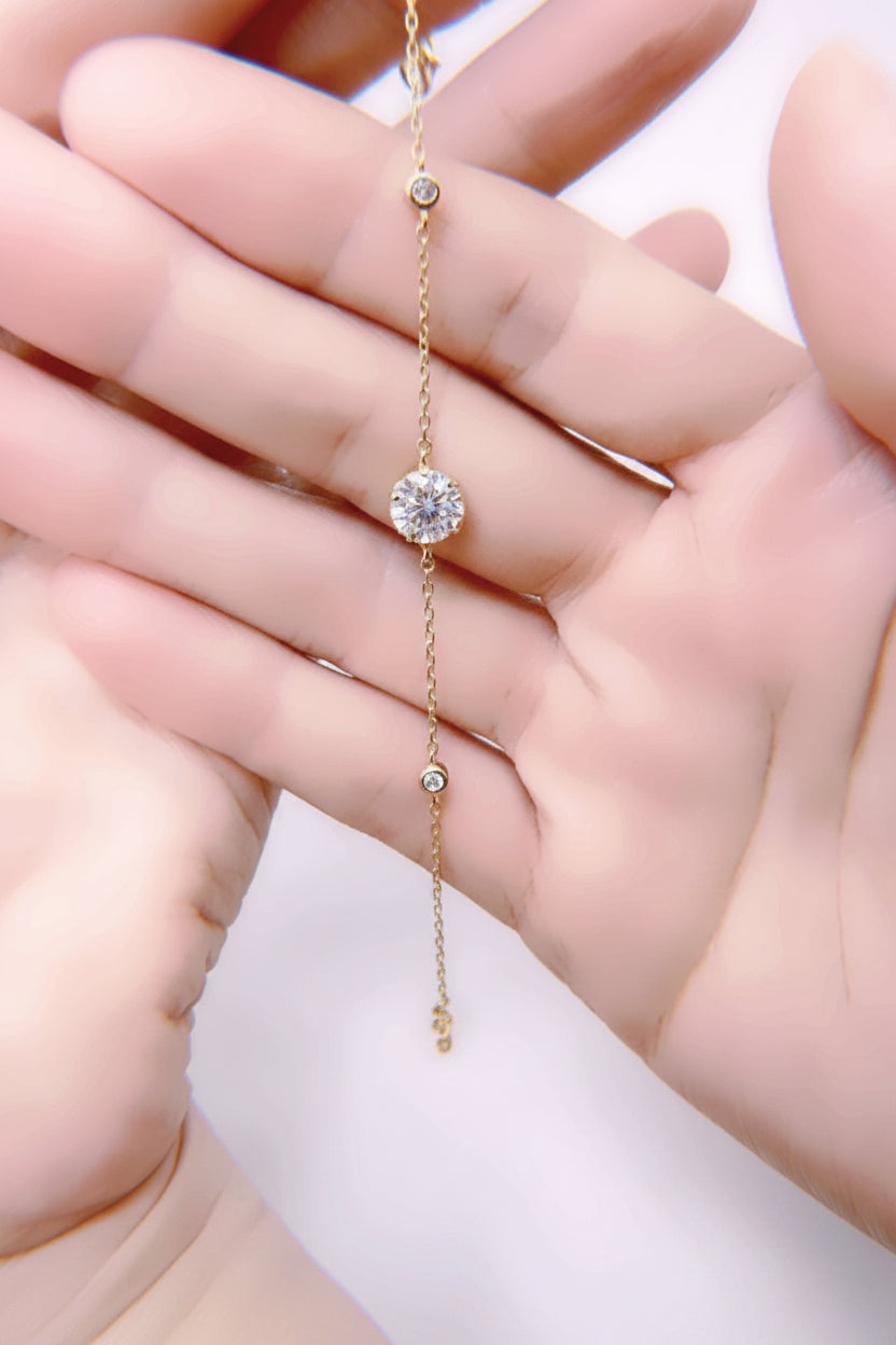 Delicate gold necklace with a small diamond pendant held between fingers  - Ali & Eve Jewels
