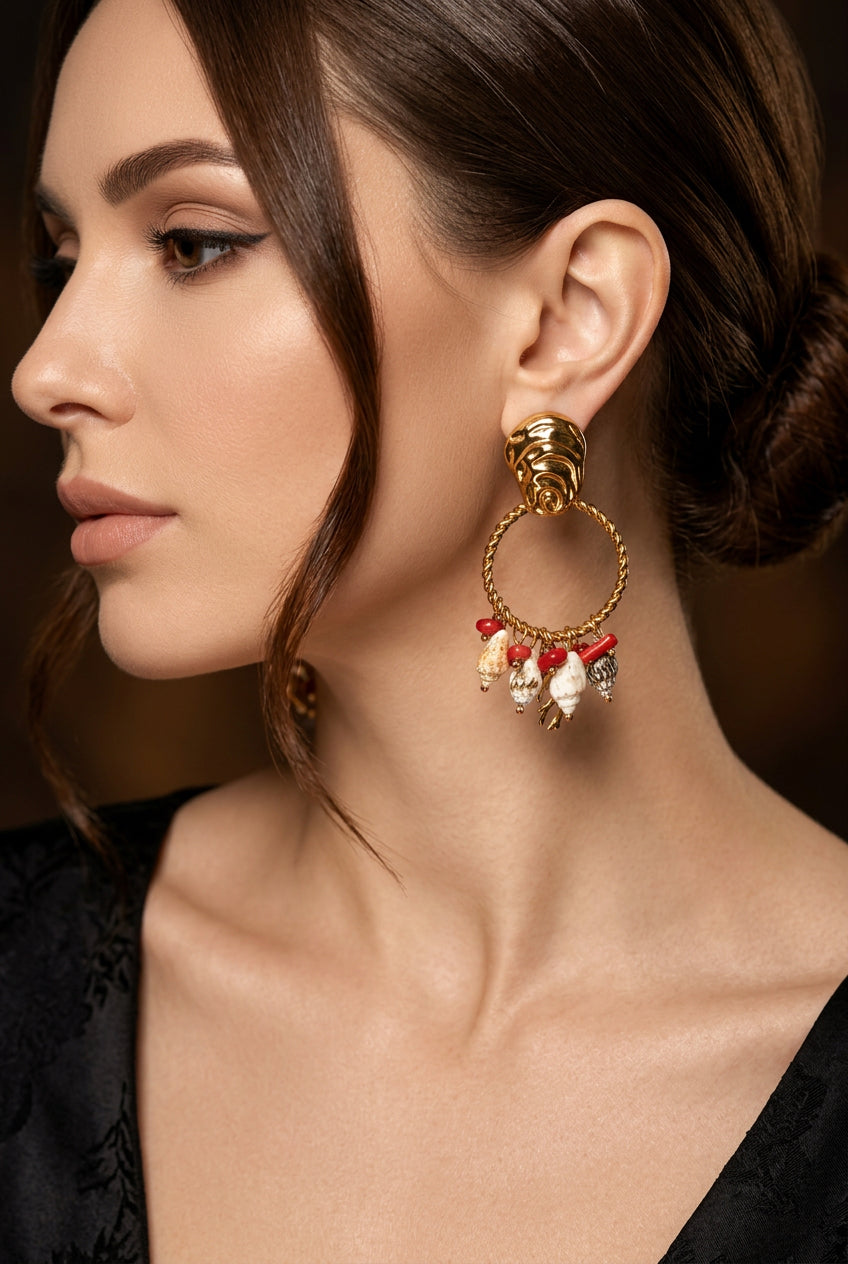 Gold earring with red and white stones worn by a person
