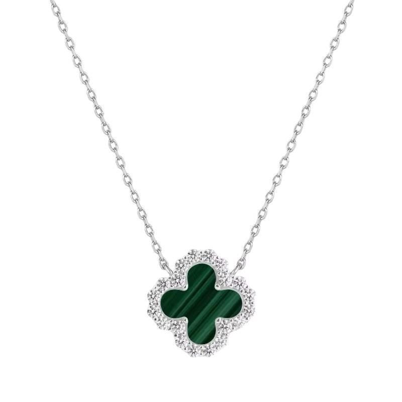 White gold necklace by Van Cleef & Arpels featuring the iconic Alhambra clover pendant with a banded green malachite center and a sparkling pavé diamond border against a white background